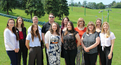 NSWA Staff team posing for a group photo outside in front of a chair lift at Snow Valley.